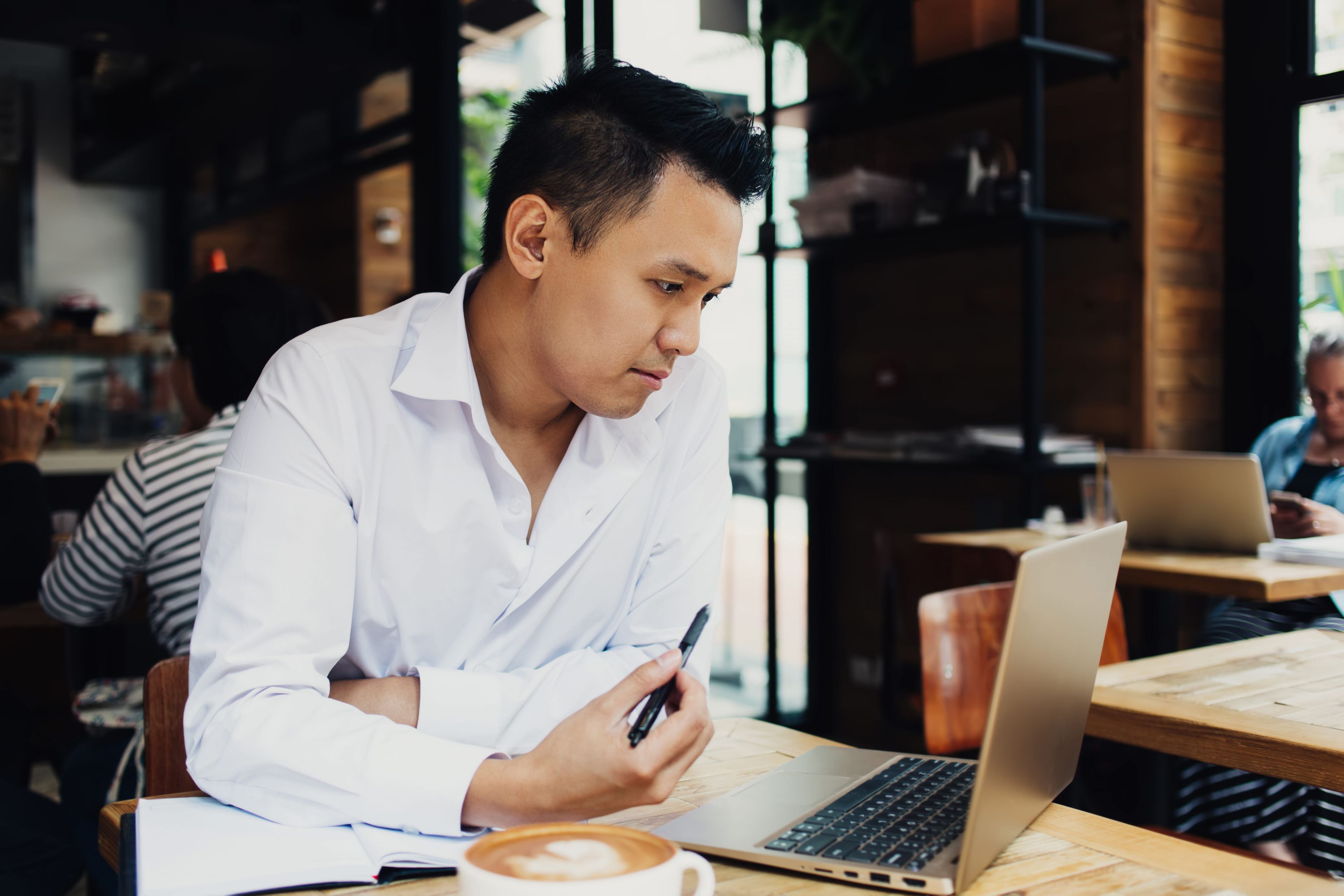 Man working in a café at his laptop