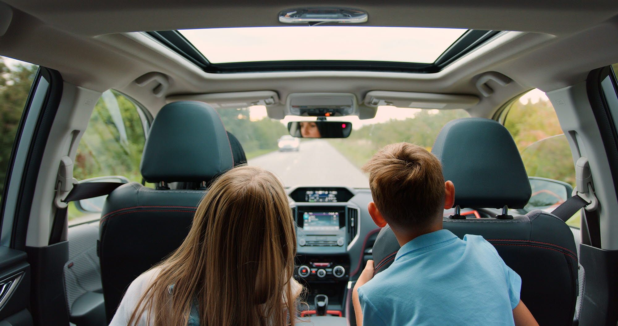 Children watching a video on a car console