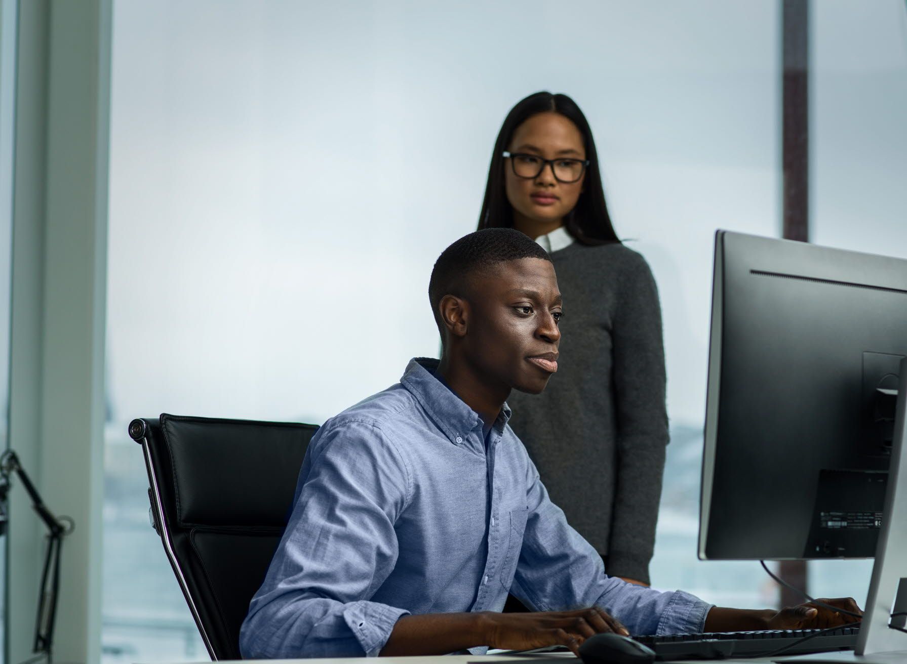 Person looking at someone's screen behind them