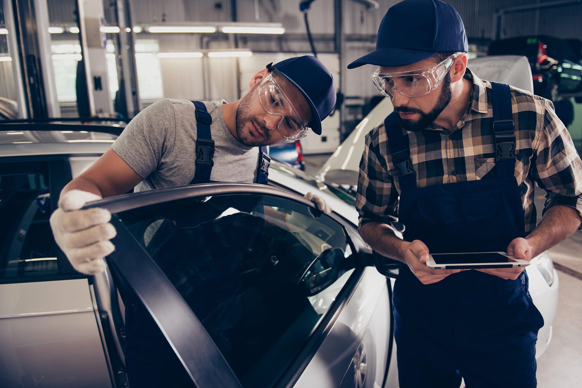 2 men visually inspecting a car window