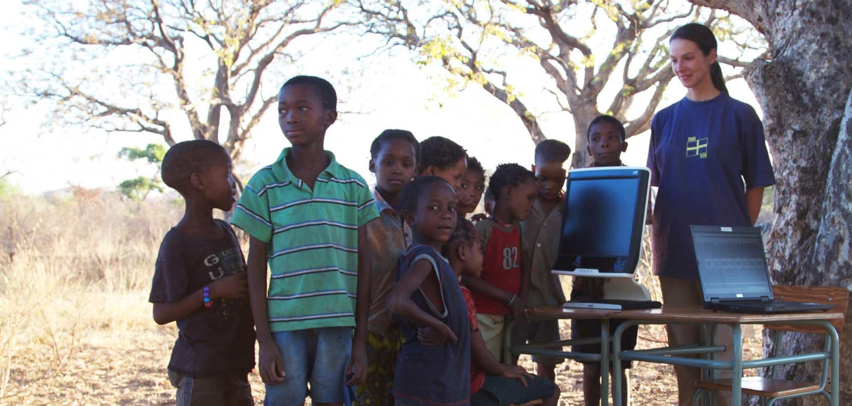 A group of school children next to a Tobii Pro T60 set up.