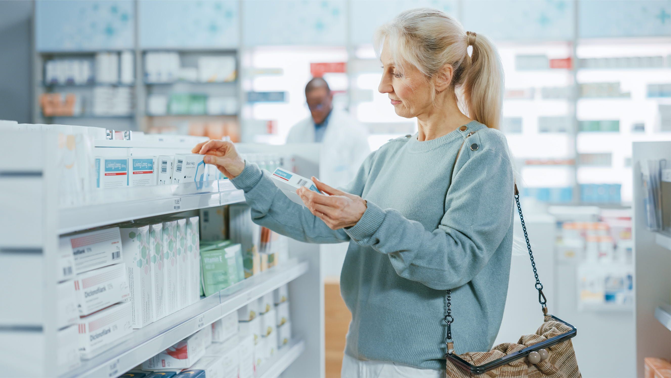 An elderly woman is choosing medicine at a pharmacy.