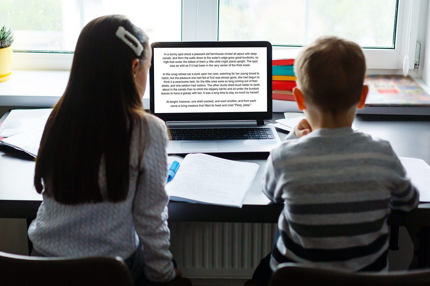 Two children reading on a computer screen